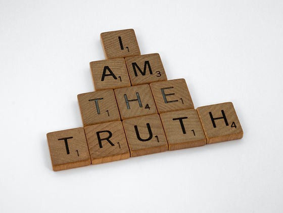 Wooden letter tiles arranged in a pyramid shape spelling 'I AM THE TRUTH'.