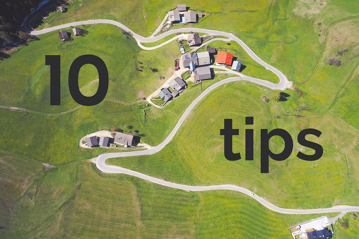 Aerial view of a rural scene featuring winding roads and a cluster of houses surrounded by green fields, with bold text overlay reading '10 tips'.